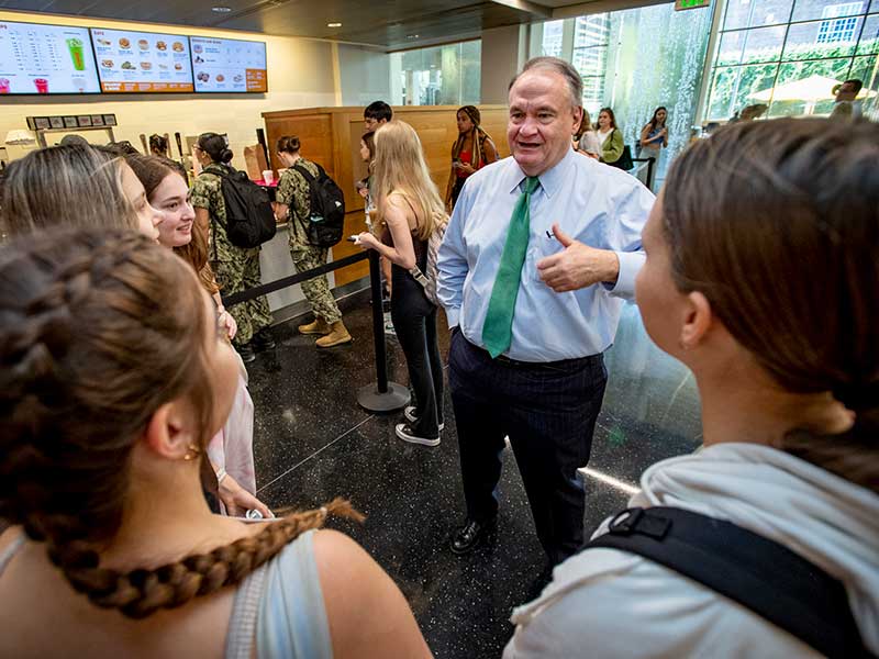 A photo of President Mike Fitts speaking with students in the food court. 